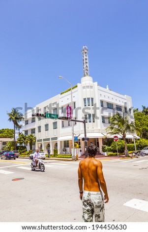 MIAMI, USA - JULY 27, 2010: people in midday heat with facade of art deco building in Miami, USA.  Art Deco architecture in South Beach is one of the main tourist attractions in Miami.