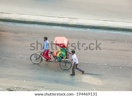 JAIPUR, INDIA - NOV 13, 2011: Rickshaw rider transports women in Jaipur, India.ycle rickshaws were introduced in Jaipur in the 1940's and have a fixed quota of licenses.
