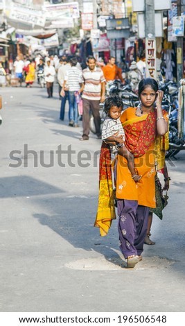 PUSHKAR, INDIA - OCTOBER 20, 2012: mother with child walks around Pushkar, India.  In India dramatically increases the number of poor people.