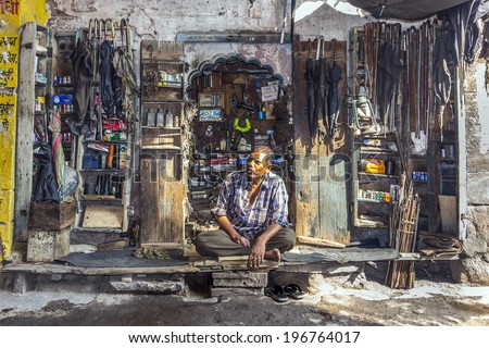 JODPUR, INDIA - OCT 23, 2012: indian man sells household goods on a street shop in Jodhpur, India. Jodhpur is the second largest city in the Indian state of Rajasthan with over 1 million habitants.