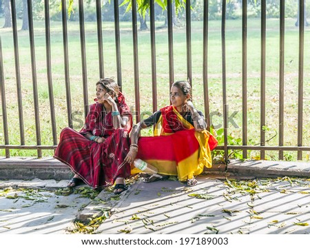 DELHI, INDIA - NOVEMBER 9, 2011: women sitting at the floor in the red fort complex in Delhi, India. Red Fort is a 17th century fort complex was designated a UNESCO World Heritage Site in 2007.