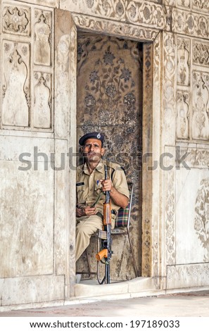 DELHI, INDIA - NOVEMBER 9, 2011: policeman with gun pays attention in the Red Fort in Delhi, India. Red Fort is a 17th century fort complex was designated a UNESCO World Heritage Site in 2007.