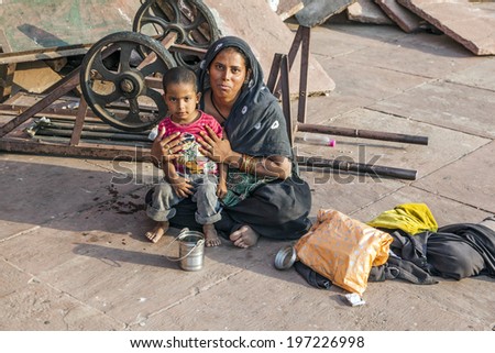 DELHI, INDIA - NOV 8, 2011: mother with child rests on the courtyard of Jama Masjid Mosque in Delhi, India. Jama Masjid is the principal mosque of Old Delhi in India.