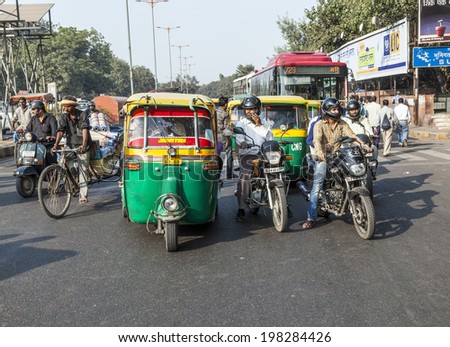 DELHI, INDIA - NOV 11, 2011: Transporting people through city on auto rickshaw in Delhi, India. The classical auto rickshaw is the unique vehicle of local transportation in several Asian countries.