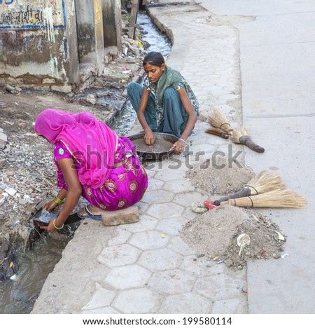 BIKANER, INDIA - OCT 24, 2012: woman tries to find gold dust in the canalisation of the gold smith area in Bikaner, India.