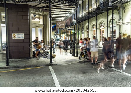 NEW ORLEANS, USA - JULY 14, 2013: people in the French Quarter with bands playing Jazz in New Orleans, USA. Tourism provides a much needed source of revenue after the devastation of Hurricane Katrina.