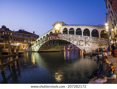 VENICE, ITALY - APRIL 11, 2007: unidentified people watch the Rialto bridge by night in Venice, Italy. Canale Grande is 3,800 m long, 30-90 m wide with an average depth of 5 meters.