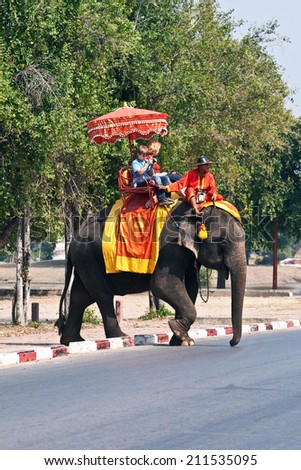 AYUTTHAYA, THAILAND DEC 23: unidentified tourists ride on elephant in the Historical Park on DEC 23, 2009 in Ajutthaya, Thailand. It is called a must in Ayutthaya and costs about 1000 BATH for 30 min.