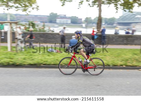 COLOGNE, GERMANY- SEP 7, 2014: An athlete cycles in the Cologne Triathlon in Cologne, Germany. The event takes place first in 1984 and is performed yearly in the City area of Cologne.