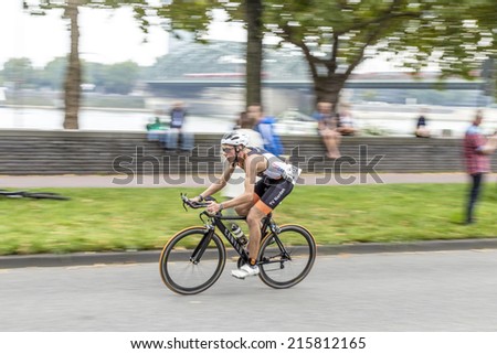 COLOGNE, GERMANY- SEP 7, 2014: An athlete cycles in the Cologne Triathlon in Cologne, Germany. The event takes place first in 1984 and is performed ince then yearly in the City area of Cologne.