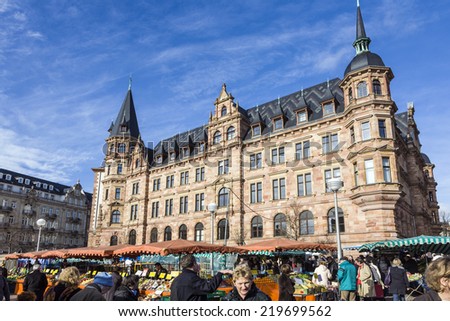 WIESBADEN, GERMANY - JAN 28, 2009: people enjoy the market at central market place in Wiesbaden, Germany. The market takes place in front of the New town hall from 1883.