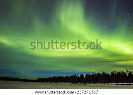 Northern Lights (Aurora borealis) over snowscape.