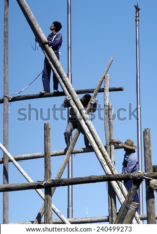 BEIJING, CHINA - JUNE 30, 1982: people work on a bamboo scaffold in Beijing, China. They wear the typical blue Mao uniform.