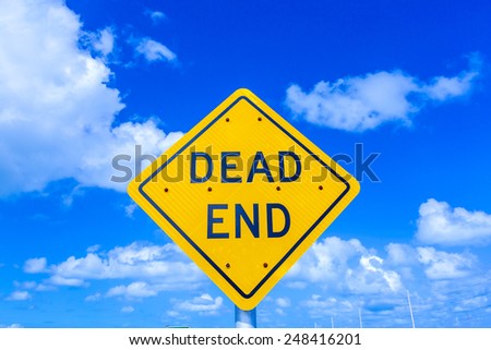 dead end street sign under blue sky with clouds