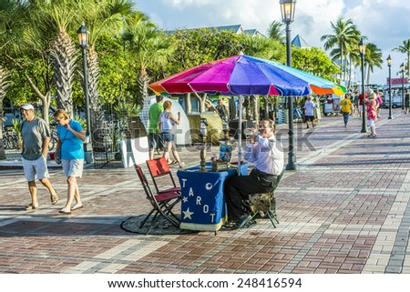 KEY WEST, USA - AUG 26, 2014: fortune teller with tarot cards waits for clients at Mallory square in Key West, USA. This place is the most popular sunset point in Key West.