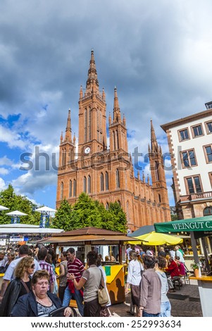 WIESBADEN, GERMANY - AUG 8, 2011: people enjoy the vine festival at central market place in Wiesbaden, Germany. The market takes place in front of the Market church fromNew town hall from 1862.