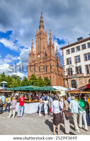 WIESBADEN, GERMANY - AUG 8, 2011: people enjoy the vine festival at central market place in Wiesbaden, Germany. The market takes place in front of the Market church fromNew town hall from 1862.