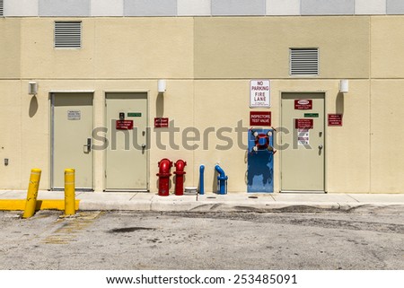 SUNRISE, USA - AUG 2, 2013: fire hydrant and emergency exit at a backwards wall of a shopping mall in Sunshine, USA. Rules fr emergency are very strict in the US and checked by the government.