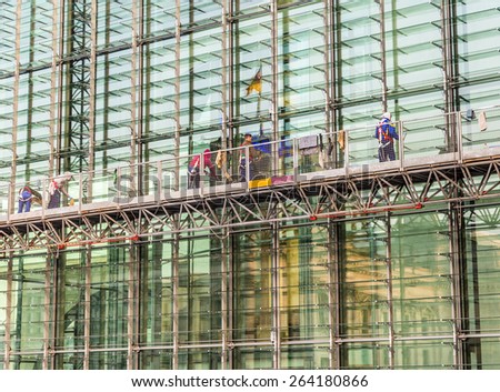 BERLIN, GERMANY - OCT 29, 2014: people in outdoor elevator clean the facade of the Paul Loebe house in Berlin, Germany. The Paul Loebe house is the office of the parliament members of the Bundestag.