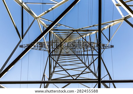 A high voltage electricity pylons against blue sky and cloud