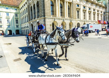 Vienna, Austria - April 24, 2015: City center Street view, people walking and fiaker with white horses in Vienna, Austria