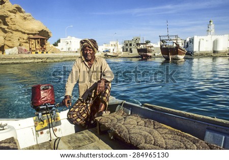 SUR - OMAN - DEC 1, 1992: man offers his ferry services to travelers in Sur, Oman. Sur is known for being an important destination point for sailorssince the 6th century.