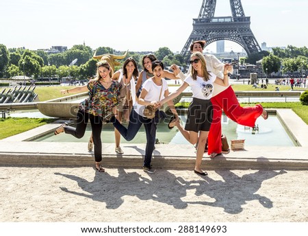 PARIS , FRANCE- JUNE 13, 2015: Tourists pose in front of Eiffel Tower in Paris, France. The Eiffel Tower is the most visited landmark in France.