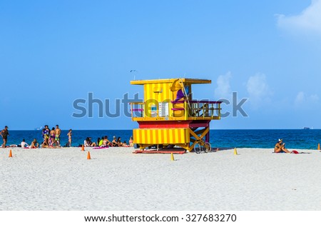 MIAMI, USA - AUGUST 18, 2014 : People enjoying the beach next to a colorful lifeguard tower in Miami, USA.