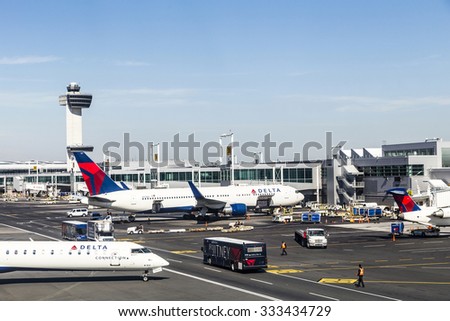NEW YORK, USA - OCT 20, 2015: Air Traffic Control Tower and Terminal 4 with Delta Air planes at the gates in JFK Airport in NY. 1963 the airport was rededicated John F. Kennedy International Airport.