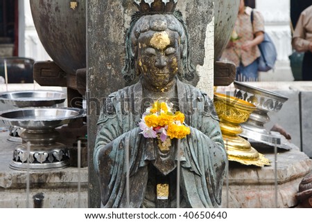 Goddess in Grand  Palace in Bangkok is decorated by faithful people with flowers
