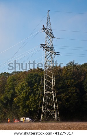 a pylon for electricity will be set up in foggy weather in beautiful landscape with acres in fog