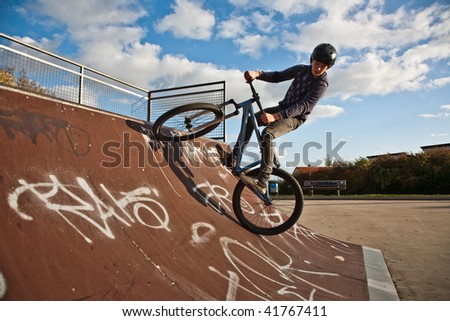 boy is biking with the dirt bike in a bike park at the halfpipe