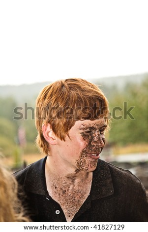 young boy is fascinated by quad driving and enjoys is, his face is dirty from mud