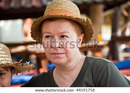 woman is relaxing, smiling and happy and has a rest in the sun at an open air restaurant