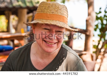 woman is relaxing, smiling and happy and has a rest in the sun at an open air restaurant