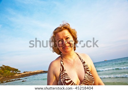 beautiful red hair women is enjoying the sun and the walk along the beautiful beach