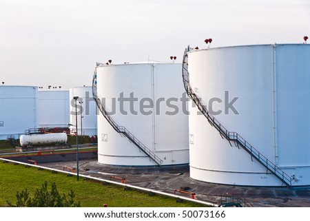 white tanks for petrol and oil in tank farm with blue sky