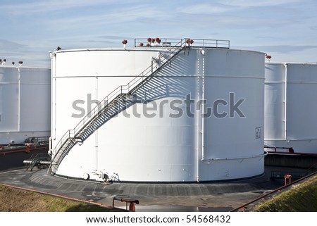 white tanks in tank farm with blue clear sky