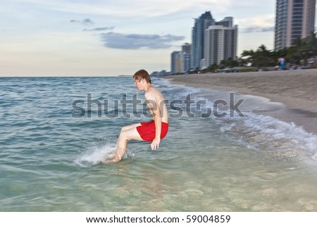 young boy jumps with speed into the ocean