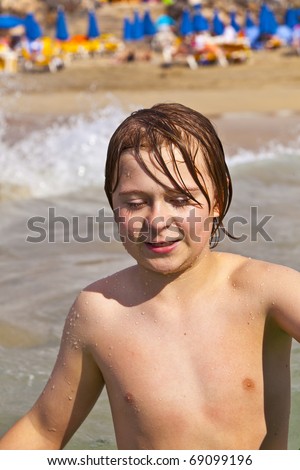 stock photo cute young boy at the beach with wet body