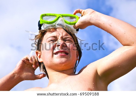 boy has fun with the diving mask at the beach