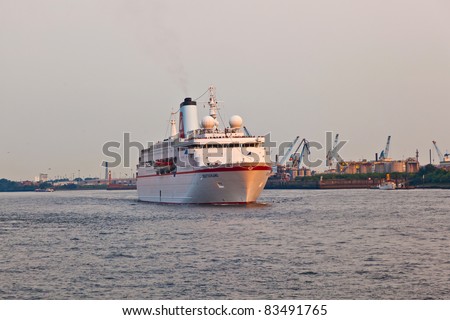 HAMBURG, GERMANY - 25 AUGUST: the famous cruise liner Deutschland with the film crew of the TV series Loveboat leaves the harbor in sunset for an overseas trip at August 25, 2011 in Hamburg, Germany.