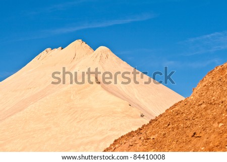 hills of sand and stone of a mine gives an impression of mountains