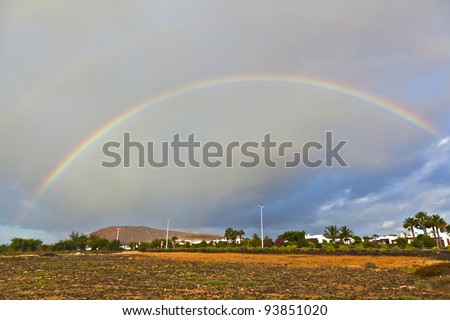 beautiful rainbow over the mountain with dark clouds