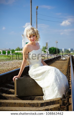 Young Married Couple on Train Tracks. New begining in old way. Bride and groom on railroad.