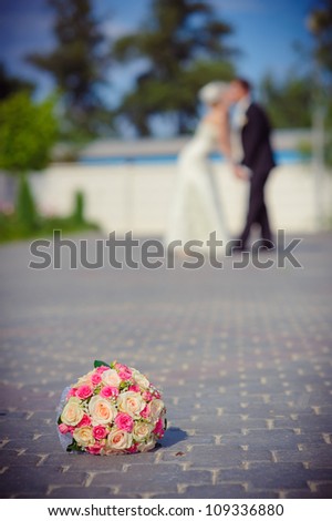 Groom and Bride in wedding dress in a park. Bridal wedding bouquet of flowers