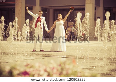 Wedding couple - new family!Happy young bride and groom outside on their wedding day - Copyspace.  wedding dress. Bridal wedding bouquet of flowers. Fountain.