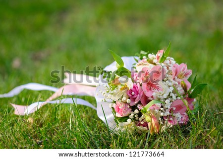 Bridal wedding bouquet of flowers. Wedding bouquet of yellow and white roses lying on a grass