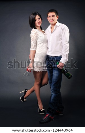 Happy young couple in love standing with two glasses and champagne