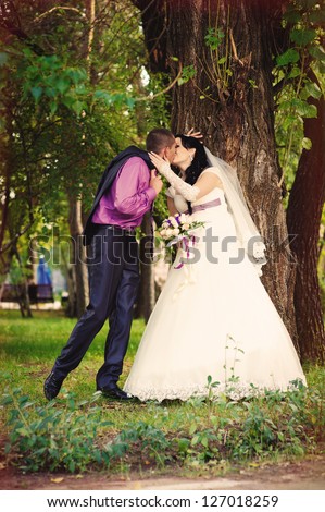 bride and groom near the tree in a park. wedding dress. Bridal wedding bouquet of flowers